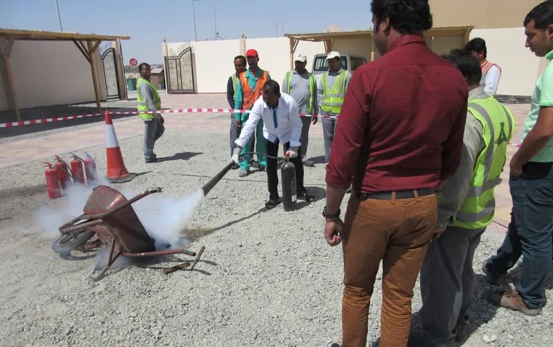 Delegates using fire extinguishers in live fire fighting training